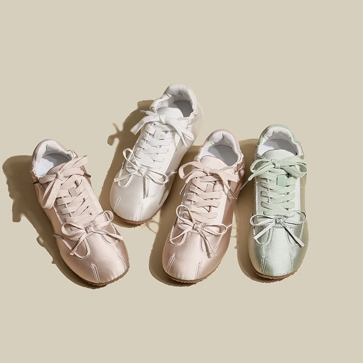 Four pairs of sneakers in different colors on a beige background