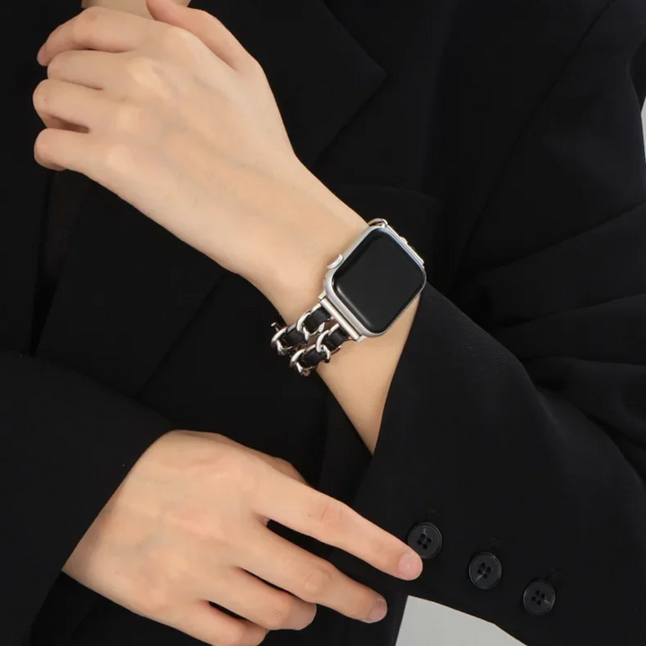 Person wearing a black smartwatch on a dark suit background