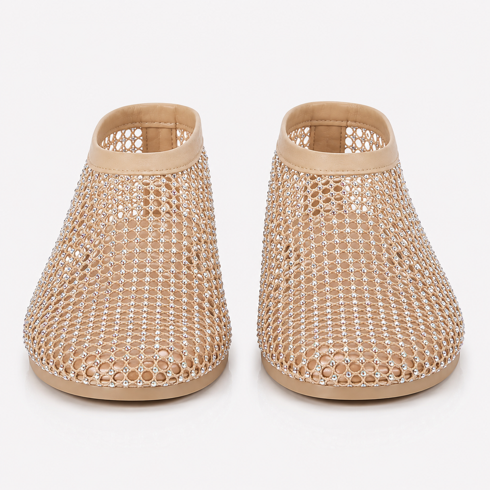 A pair of beige mesh slip-on shoes embellished with sparkling clear rhinestones, shown from the front on a light gray background.