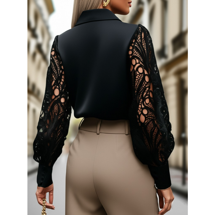 Person wearing a black blouse with lace sleeves and beige pants on a blurred street background
