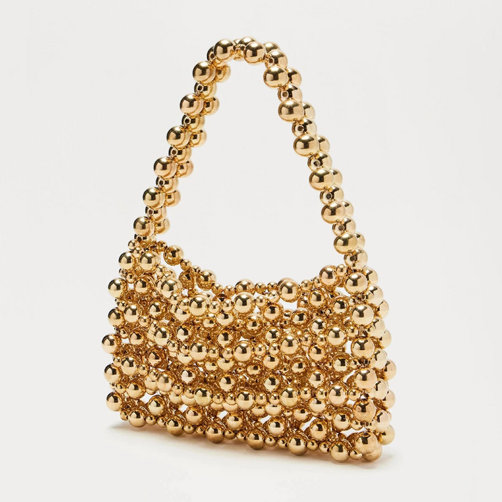 Gold beaded handbag on a white background