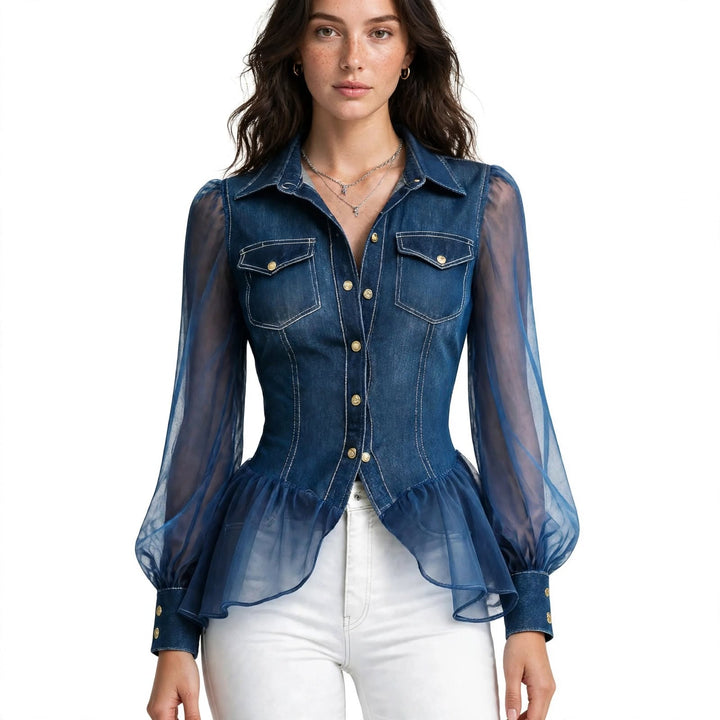 A woman wearing a blue denim button-up blouse with sheer mesh long sleeves and a ruffled peplum hem, paired with white pants, against a plain white background.