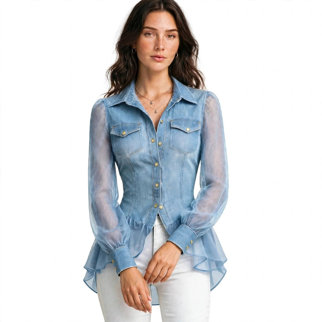 A woman modeling a light blue denim long-sleeve blouse with sheer mesh sleeves, button-front closure, chest flap pockets, and a ruffled peplum hem, paired with white pants against a plain white background.