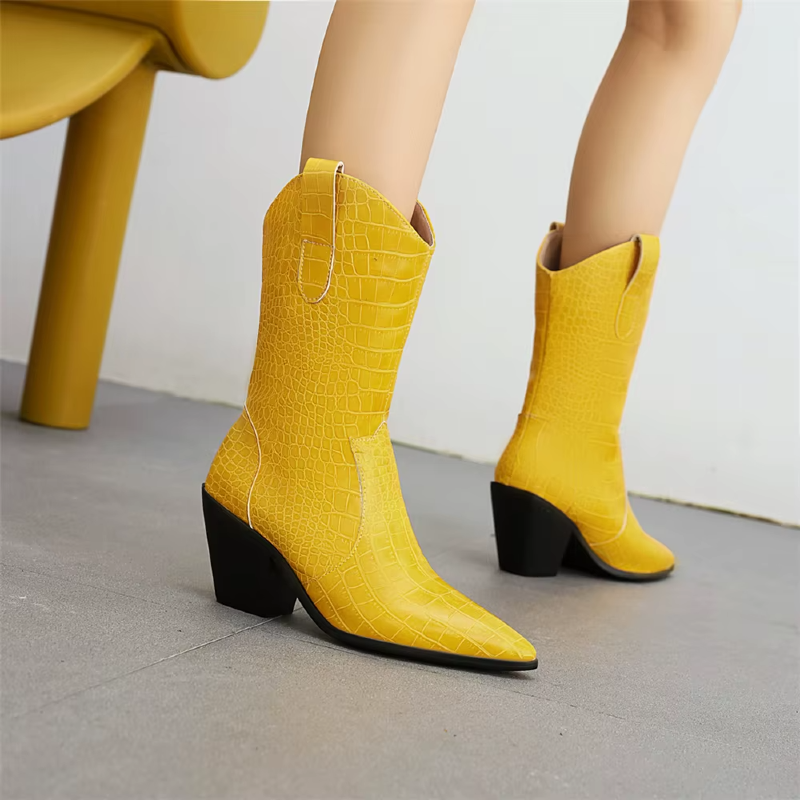 Yellow cowboy boots with black soles on a neutral background