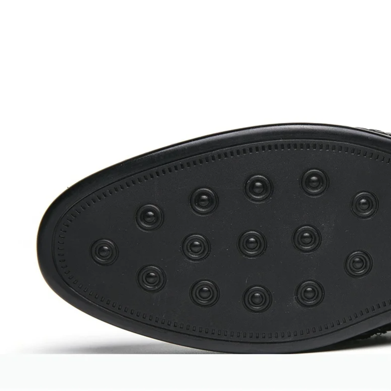 Close-up of a black shoe sole with a textured pattern on a white background