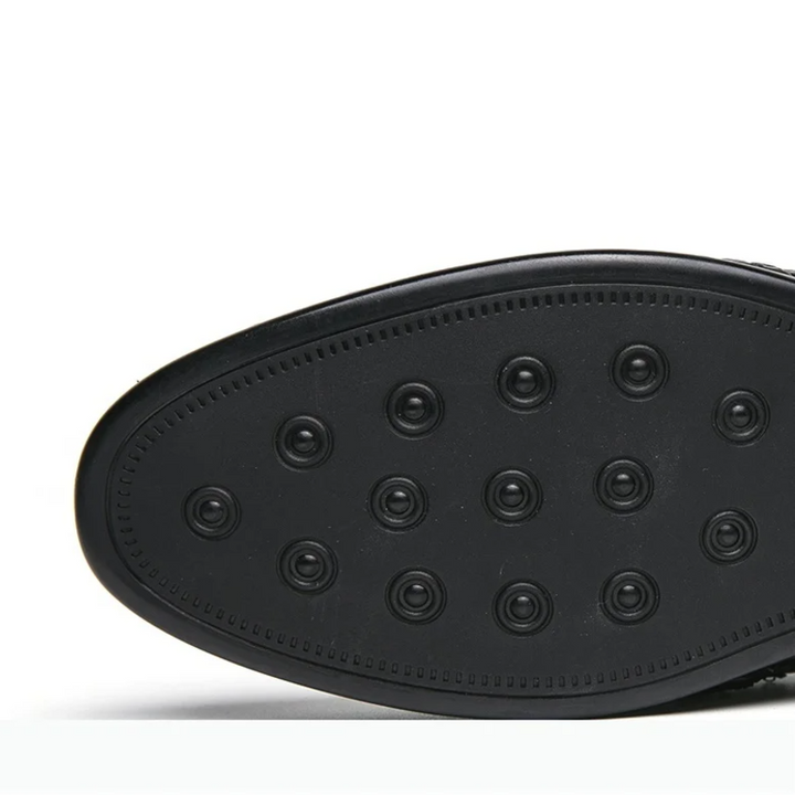 Close-up of a black shoe sole with a textured pattern on a white background