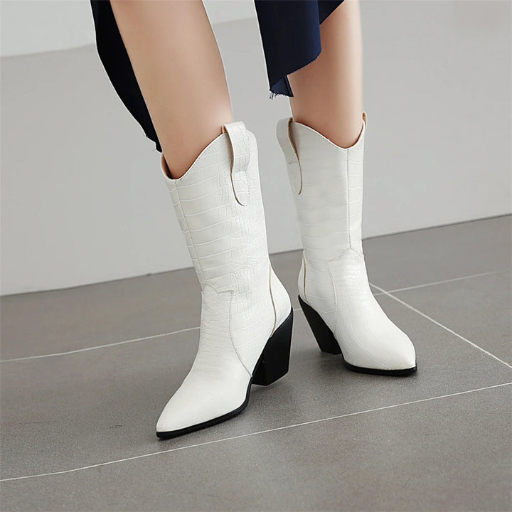 White knee-high boots with black soles on a gray floor.