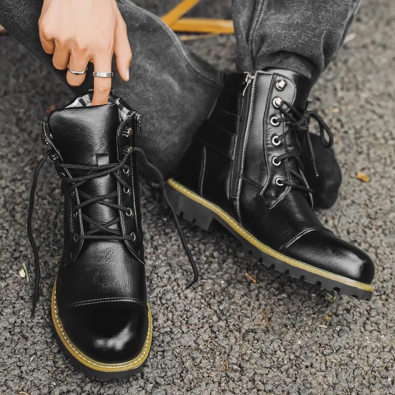 Person wearing black leather boots with yellow soles on a textured surface