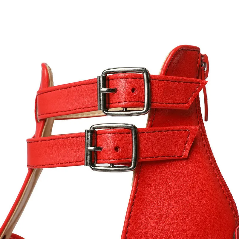 Red leather harness with silver buckles on a white background