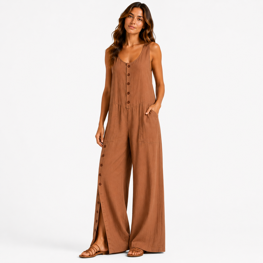 A woman modeling a sleeveless wide-leg jumpsuit in a warm brown color, featuring a buttoned front and side buttons, against a plain white studio background.