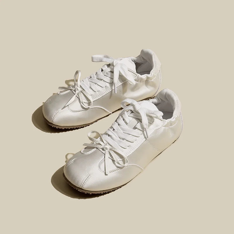 Pair of white sneakers on a beige background