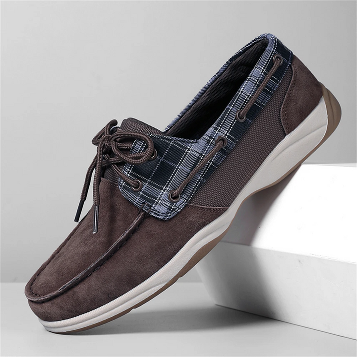 Brown suede shoe with plaid accents on a light gray background
