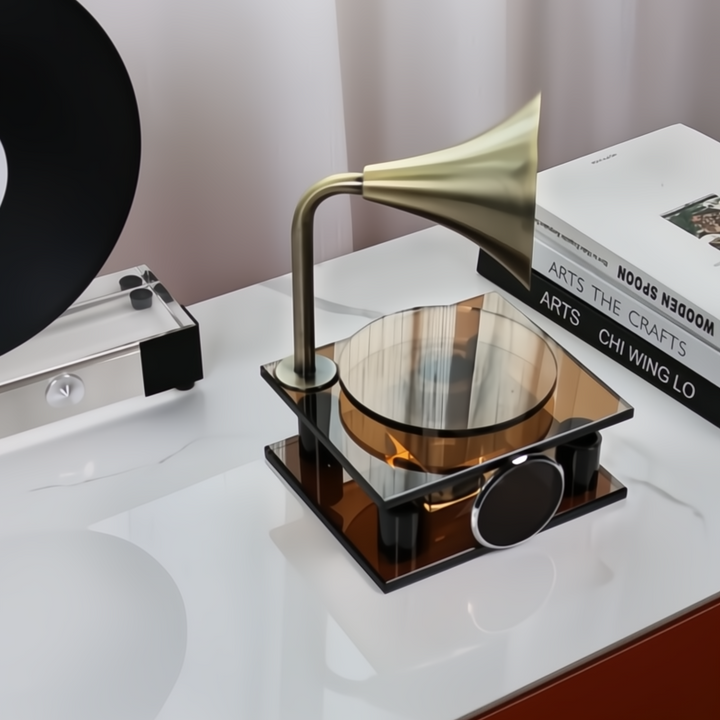 Vintage-style gramophone on a white surface with books in the background