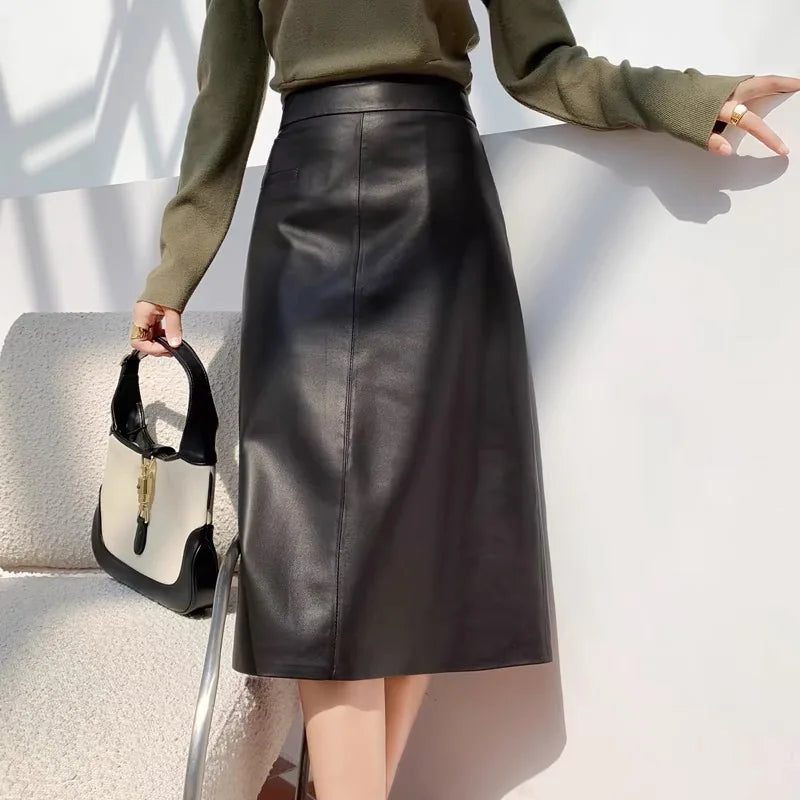Person wearing a black leather skirt with a plain background