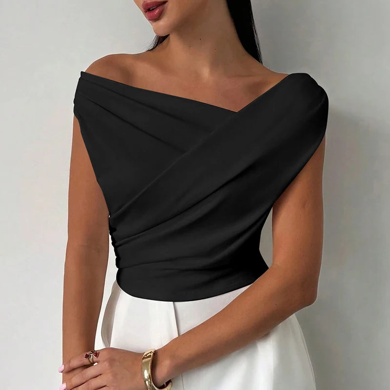 Black one-shoulder top worn by a person on a plain background