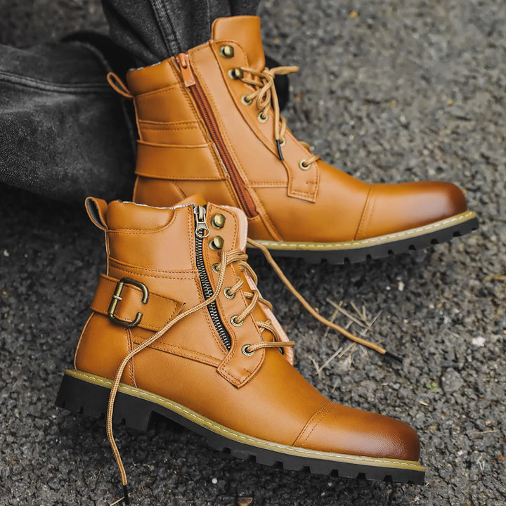 Brown leather boots with zippers and buckles on a textured surface