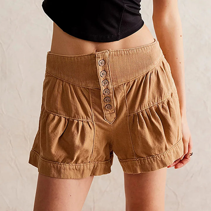 Brown shorts with button details worn by a person on a neutral background