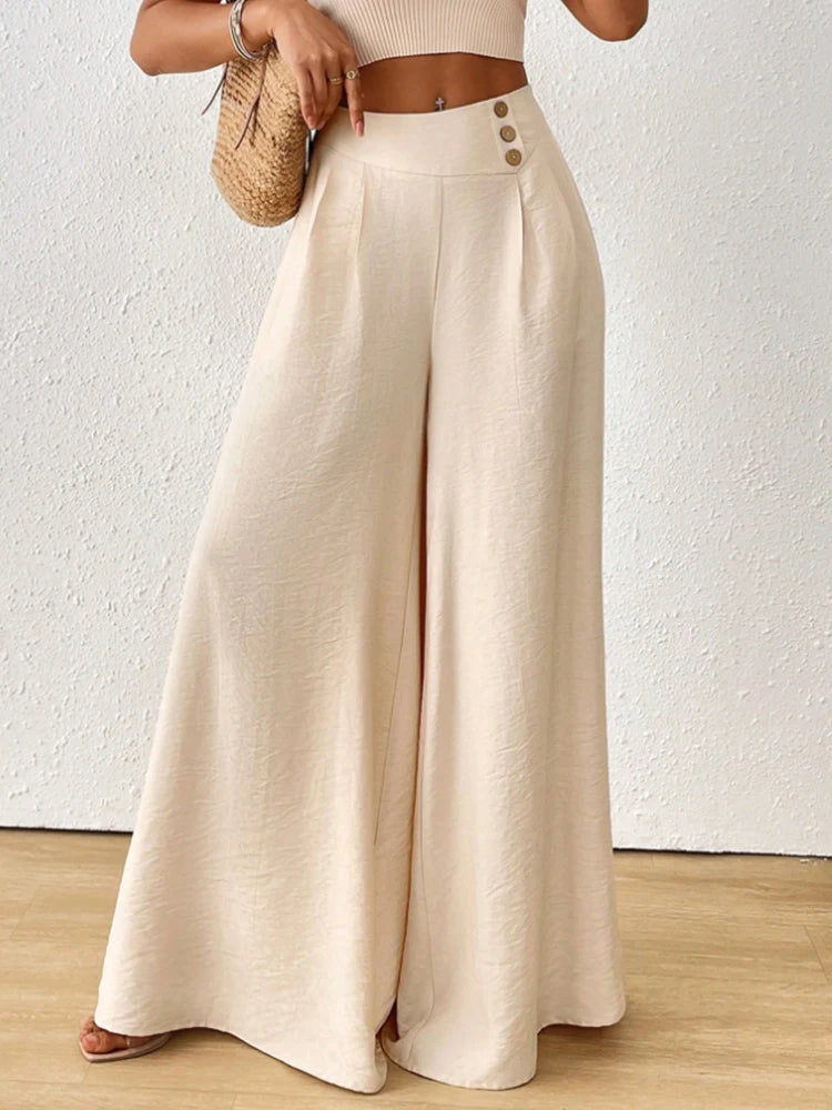 Person wearing beige wide-leg pants with a brown belt against a white background