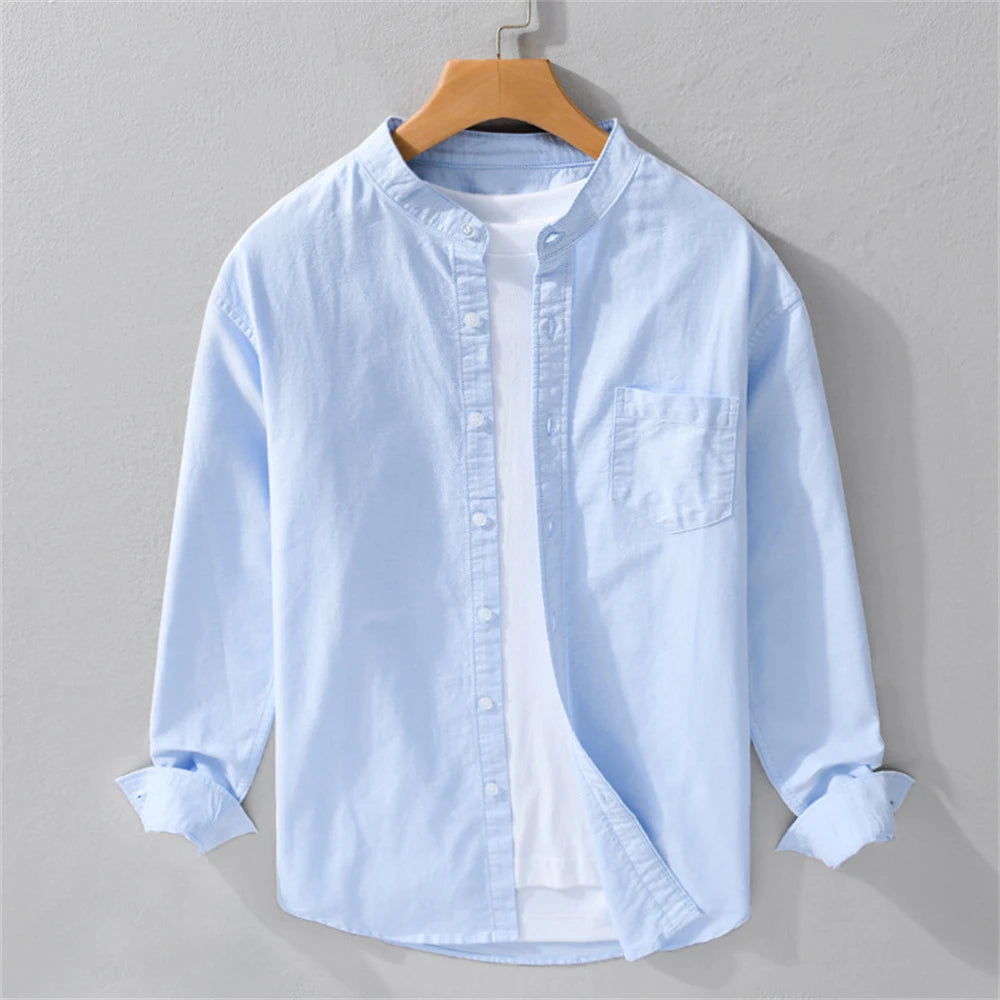 Light blue shirt on a wooden hanger against a gray background
