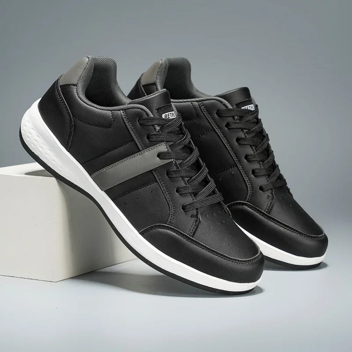 Black sneakers with white soles on a gray background