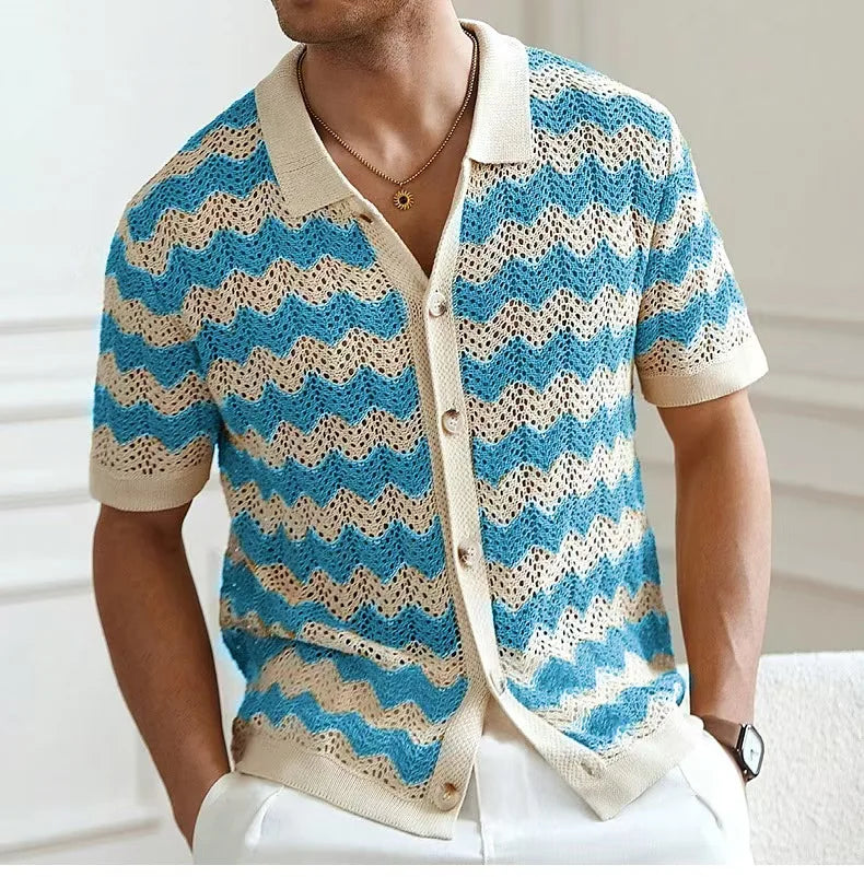 Man wearing a blue and beige patterned cardigan with a blurred background