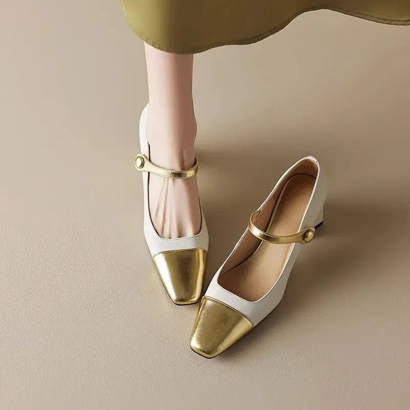 White shoes with gold toes and straps on a beige background