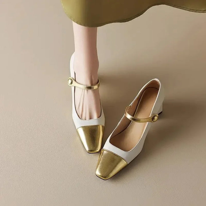 White shoes with gold toes and straps on a beige background