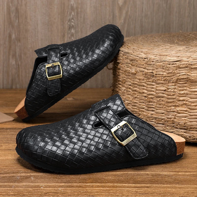 Black woven shoes with gold buckles on a wooden surface