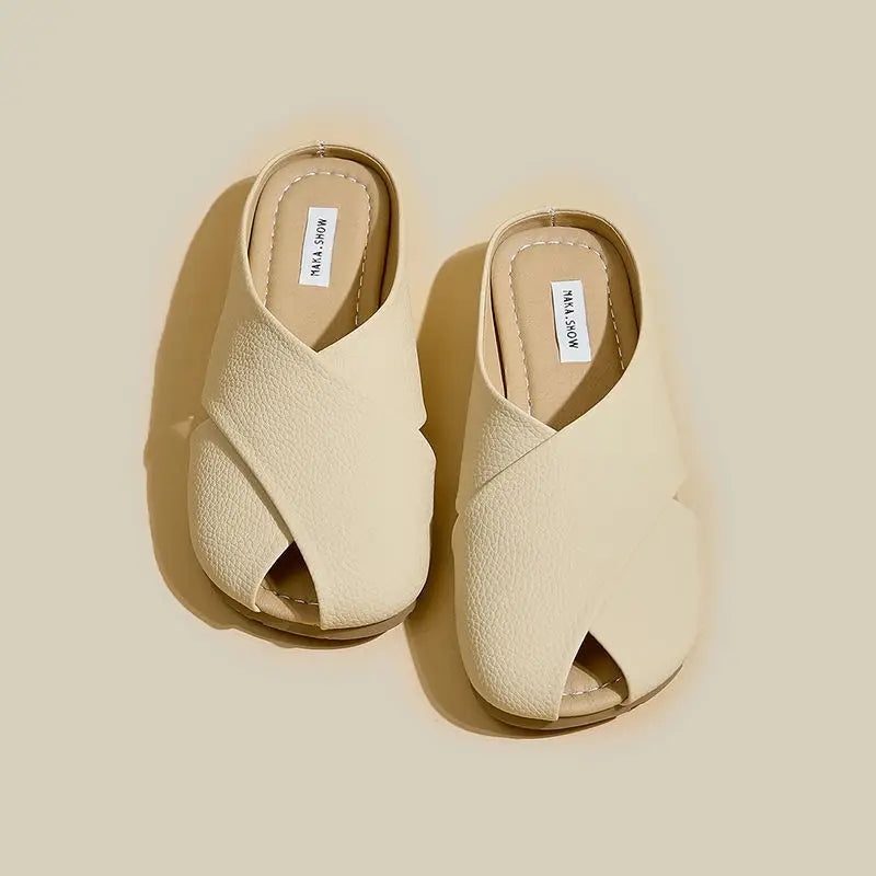 Pair of beige open-toe sandals on a beige background