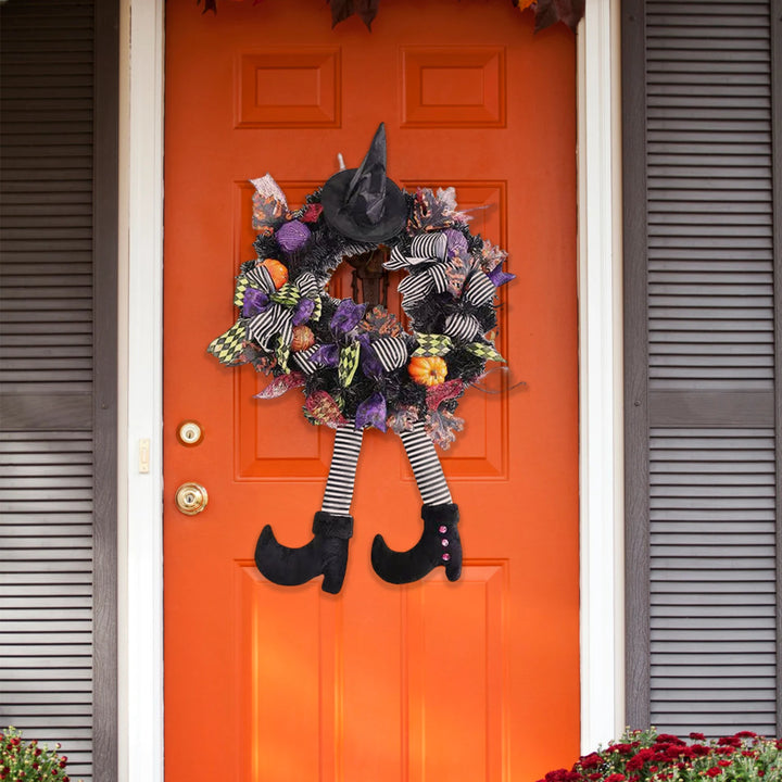 Halloween wreath with witch legs on an orange door