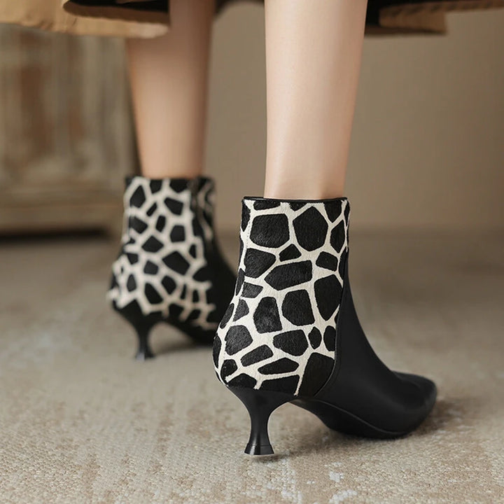 Black and white patterned high-heeled ankle boots on a neutral background