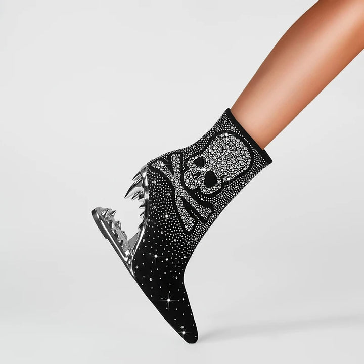 Black ankle boot with skull design and rhinestones on a light gray background
