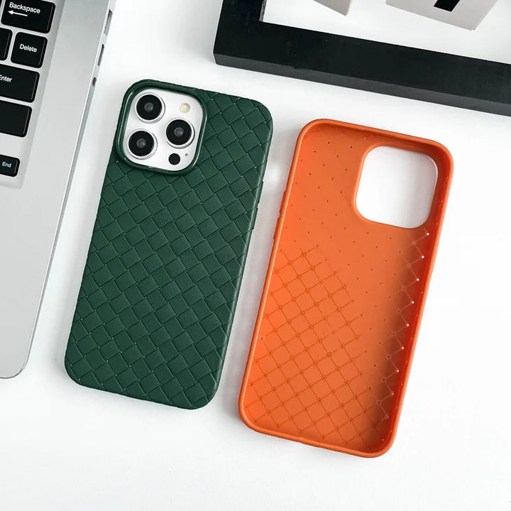 Green and orange phone cases on a white surface with a laptop.