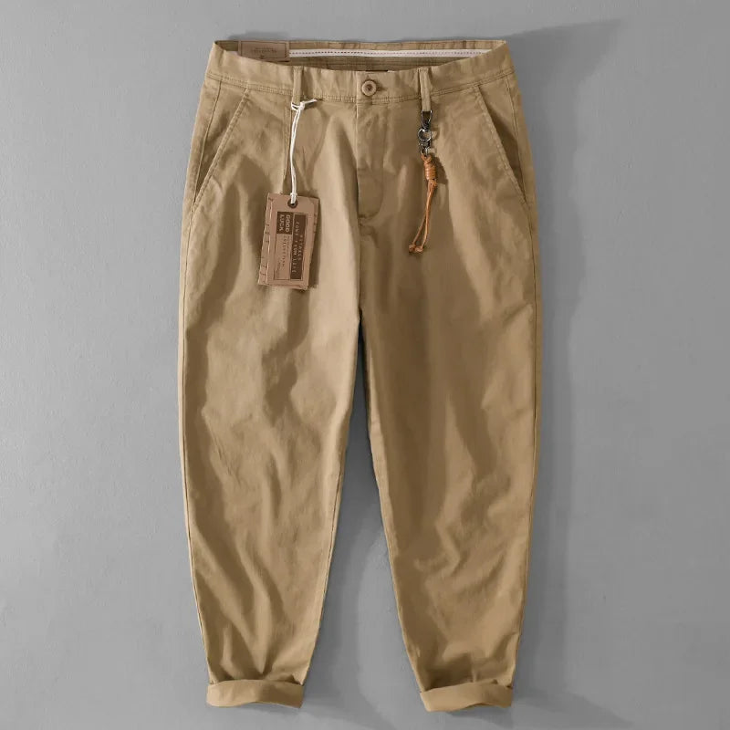Beige pants with a tag on a gray background