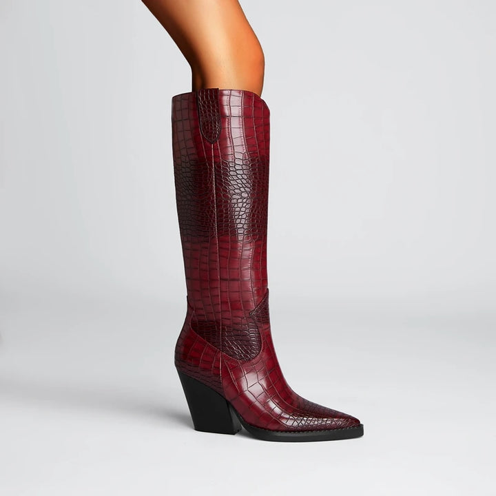 Red knee-high boot with black heel on a light gray background