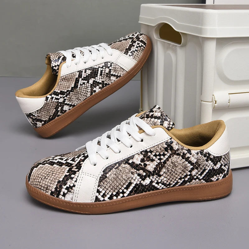 Pair of snakeskin-patterned sneakers with white accents on a gray surface.
