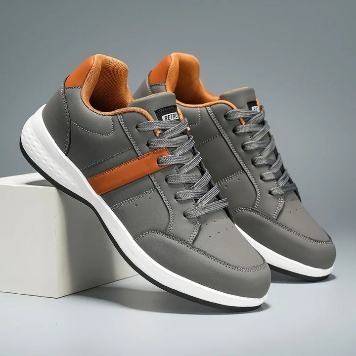 Gray sneakers with orange accents on a gray background