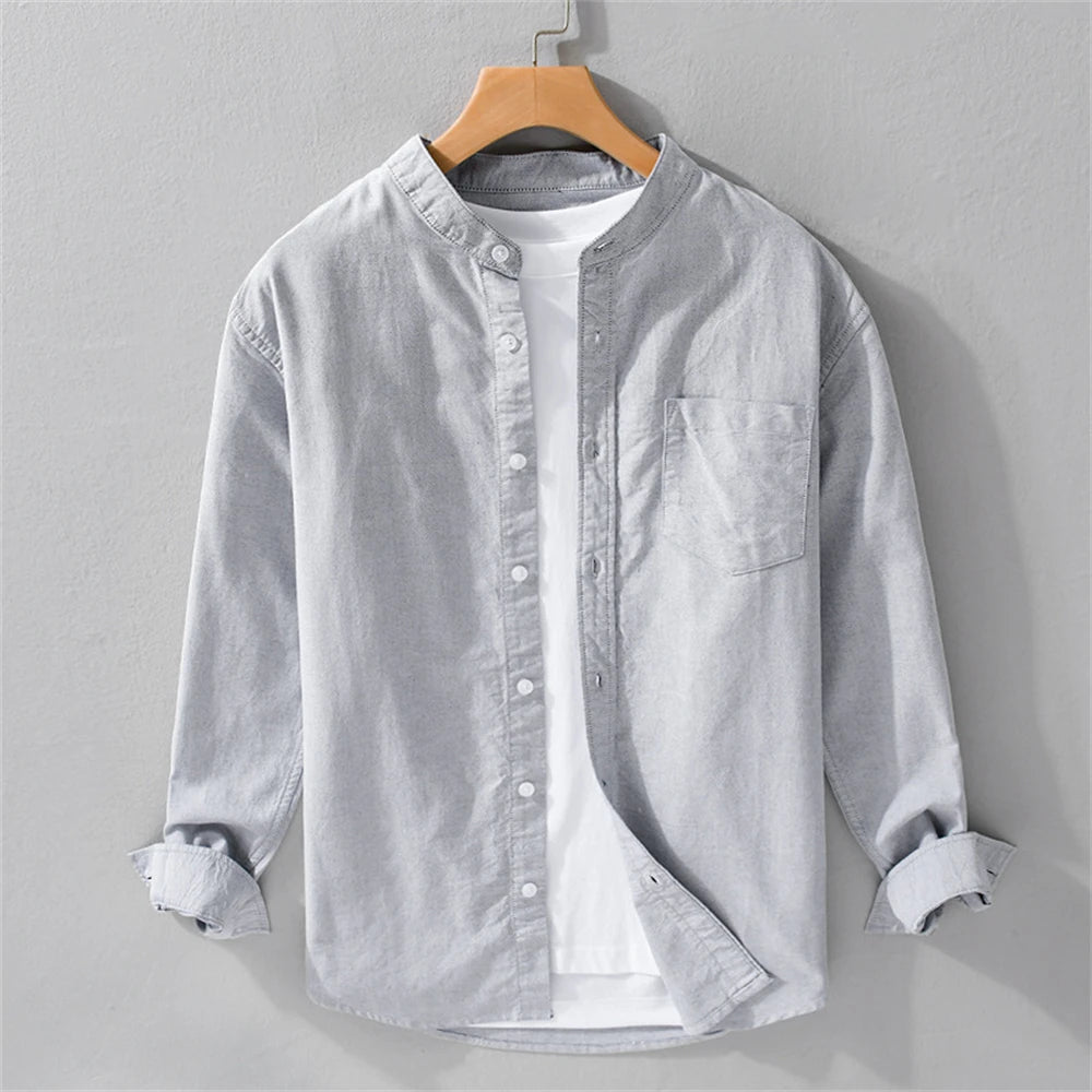 Light gray button-up shirt on a wooden hanger against a gray background