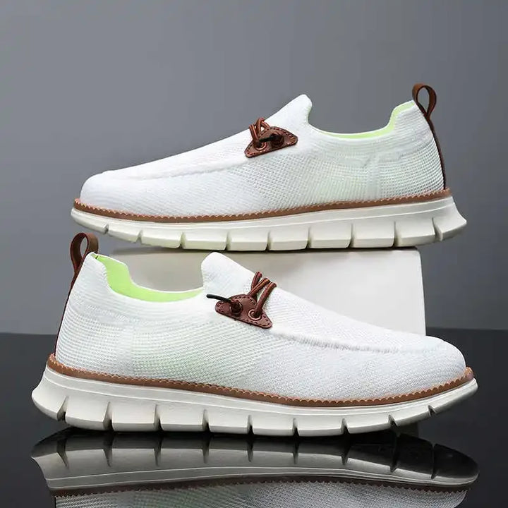 White sneakers with brown accents on a reflective surface and gray background