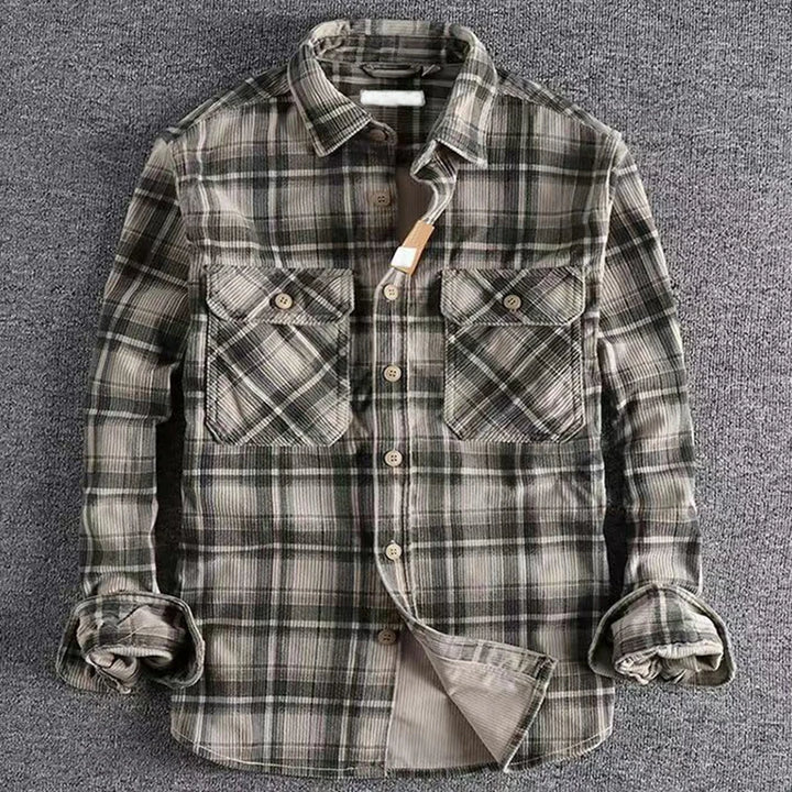 Plaid shirt with rolled-up sleeves on a gray background