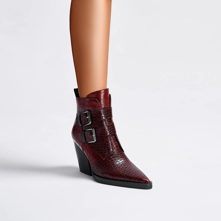 Red leather ankle boot with a buckle on a light gray background
