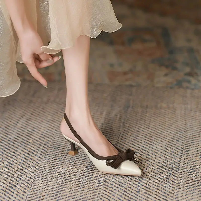 Woman wearing elegant shoes with a bow on a textured floor