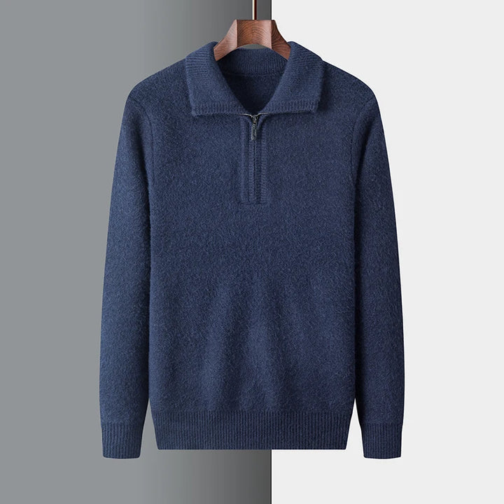 Blue sweater on a hanger against a gray background