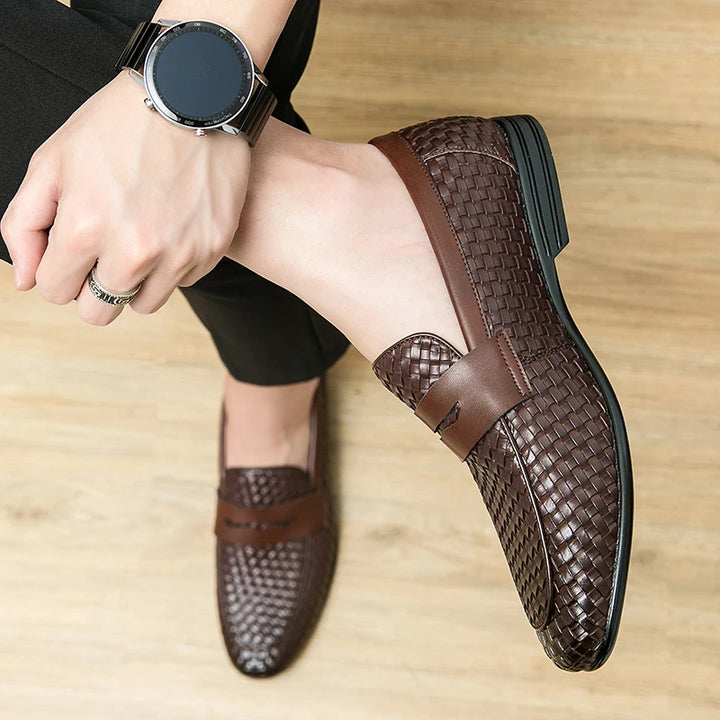 Brown woven shoes worn by a person on a wooden floor