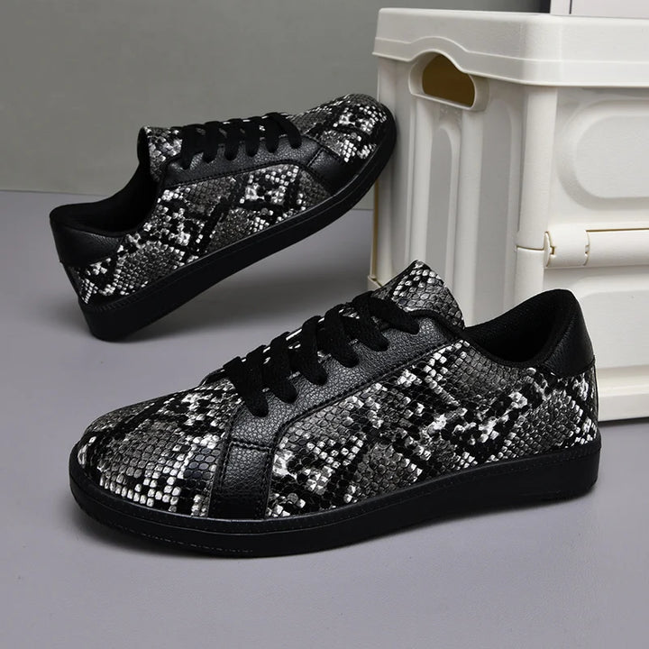 Black and silver sequin sneakers on a gray surface with a white box in the background.