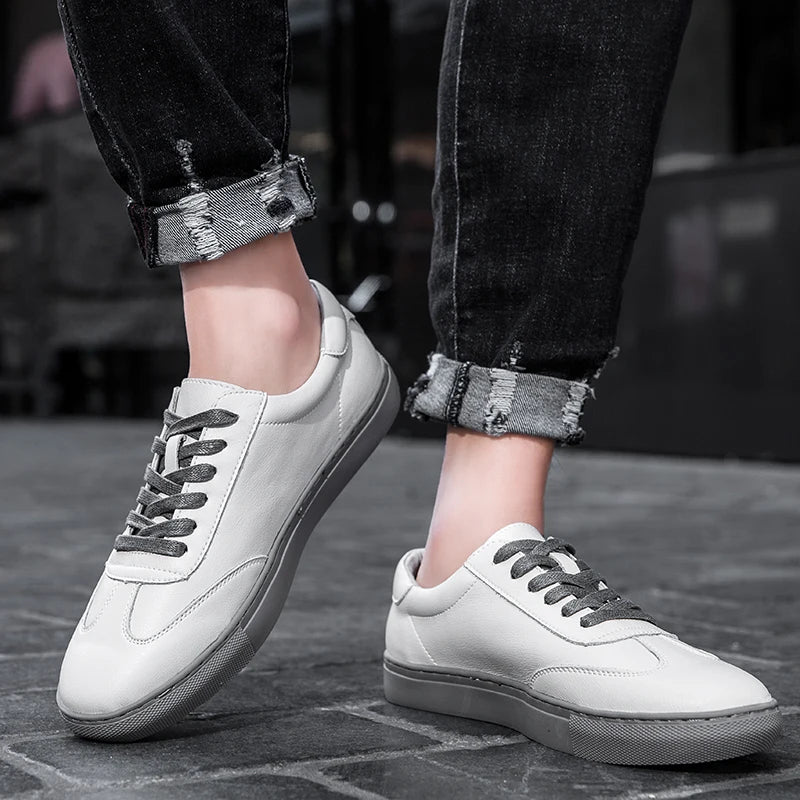 White sneakers worn with rolled-up jeans on a blurred background