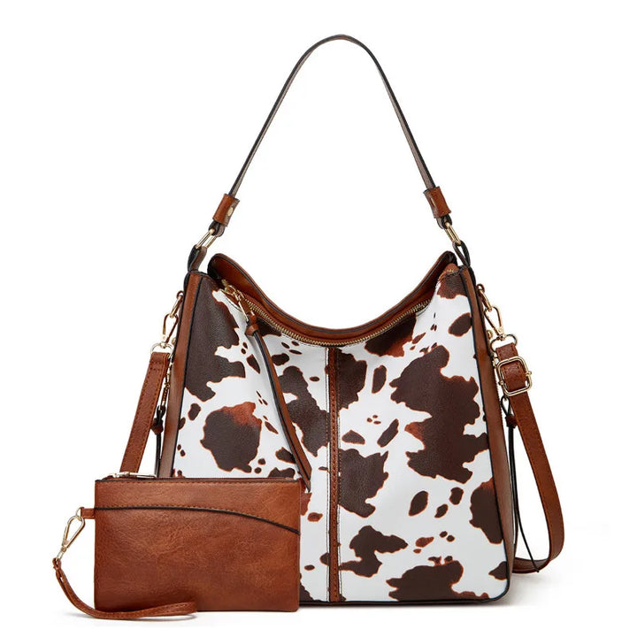 Brown and white cow print handbag with matching wallet on a white background