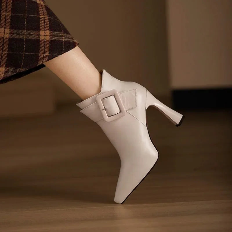 White ankle boot with a buckle detail on a blurred background