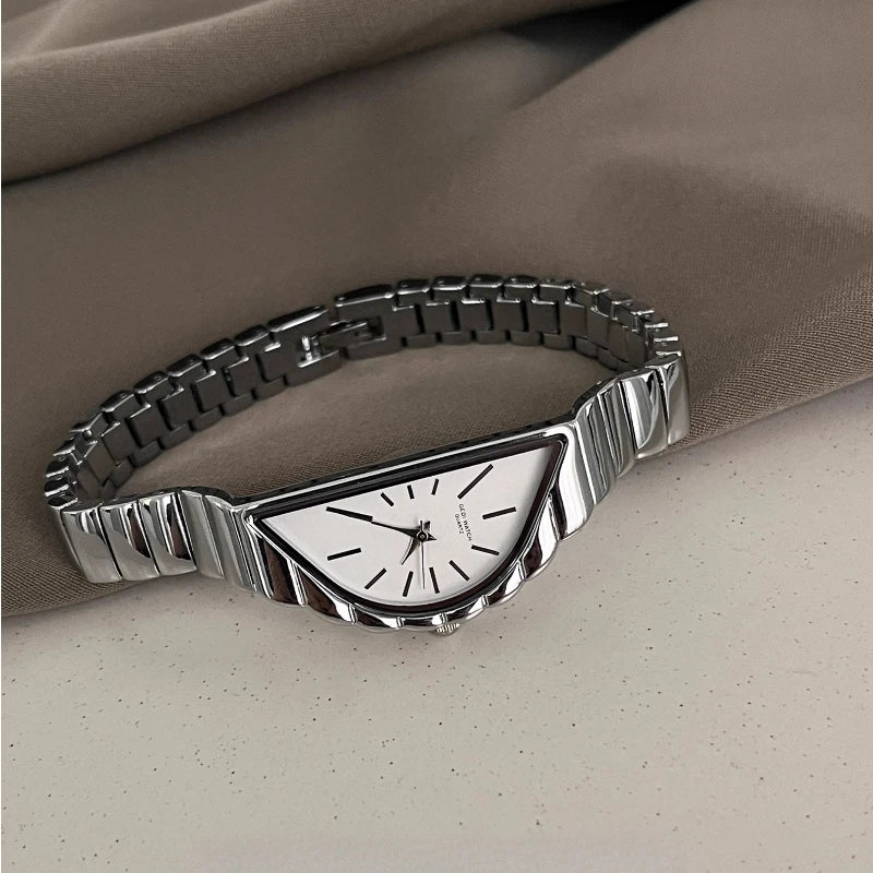 Silver bracelet watch on a beige fabric background