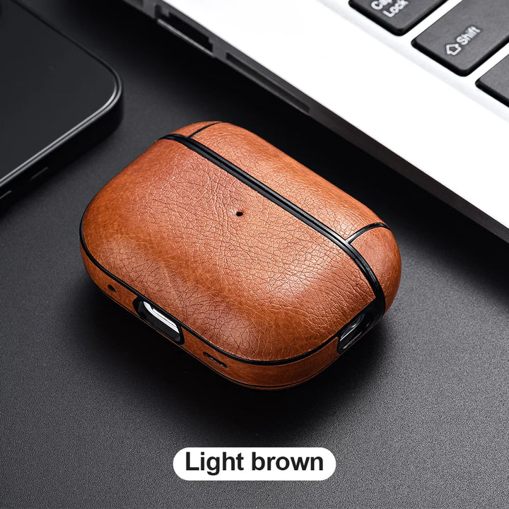 Light brown leather case on a dark surface with a laptop in the background